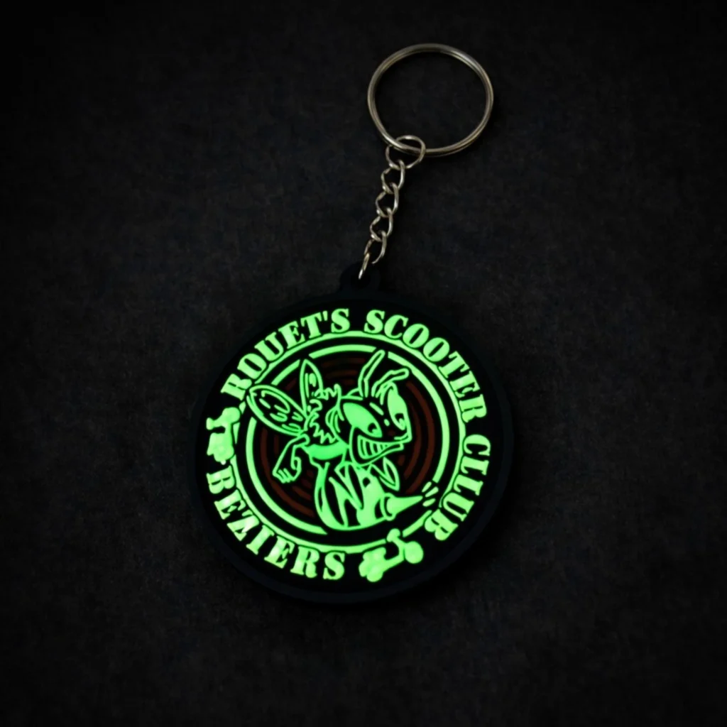 Brelok gumowy PVC z logo firmy świecący w ciemności na zielono.